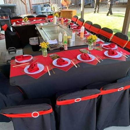 Elegant hibachi outdoor table setup with red and black decor